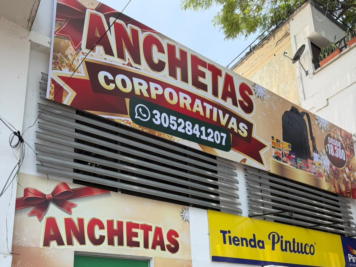 Fachada real del punto de venta Anchetas Corporativas en Santa Mónica, Cali, con su letrero y puerta decorada de Navidad